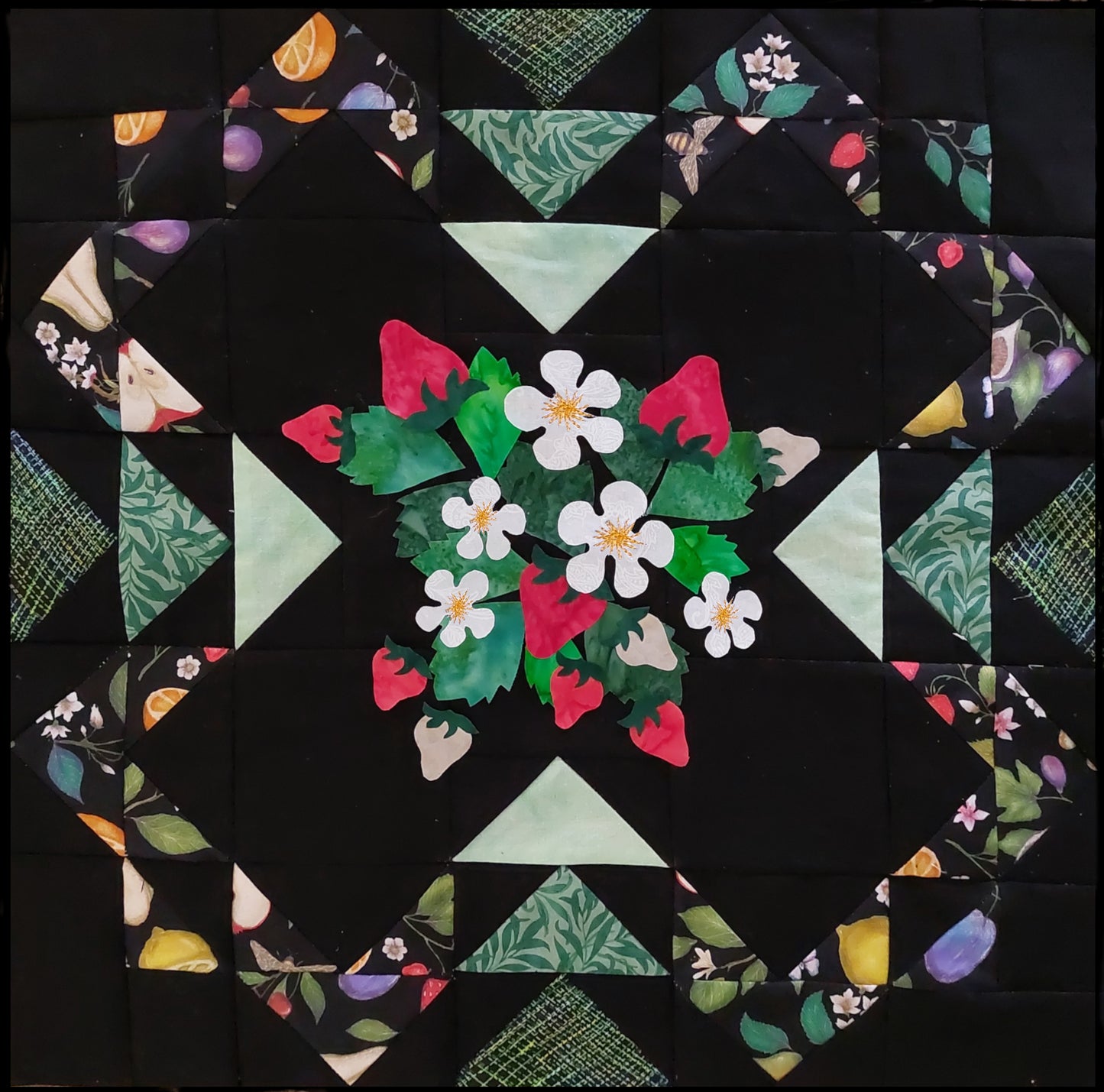 Strawberry Patch quilt using pieced triangles and strawberry applique block