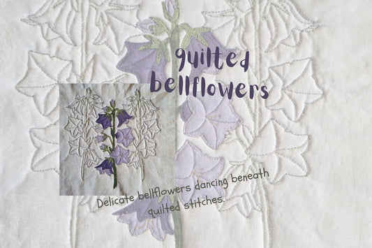 Close-up of quilted bellflowers with delicate stitching and softly textured background fabric.