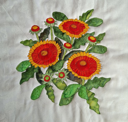 Applique design of red and yellow Gaillardia flowers with various green leaves on a white-on-white background fabric. The 82th flower applique in the BOW flower collection