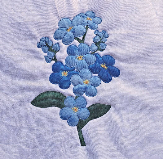 forget-me-not flower or Myosotis flower applique block in blues on a white-on-white background fabric