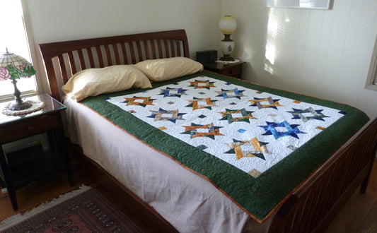 starry patchwork quilt called Entwined Star displayed on bed - quilt pattern available