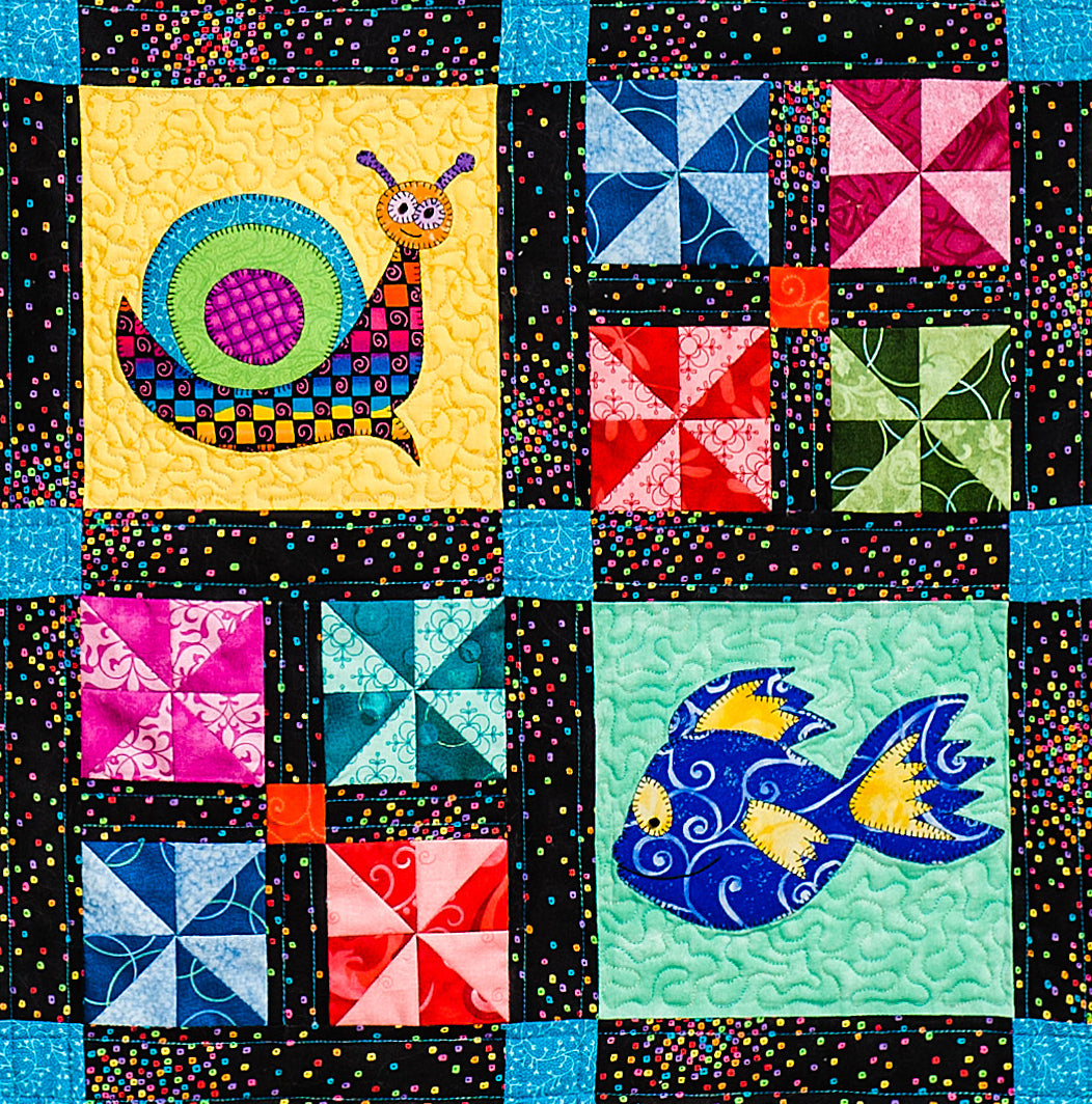 close up of some blocks in baby quilt pattern with ocean theme including snail, jellyfish and seahorse and simple patchwork blocks designed by Jennifer Houlden