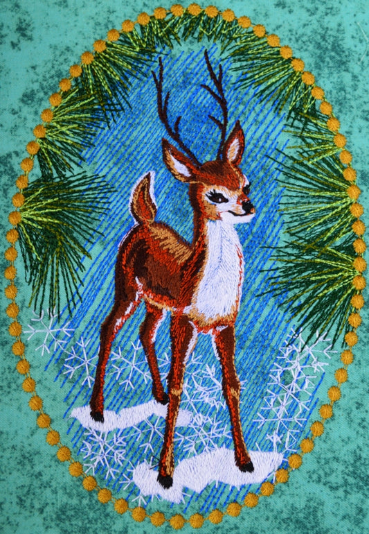 Embroidery design of a young buck in pines