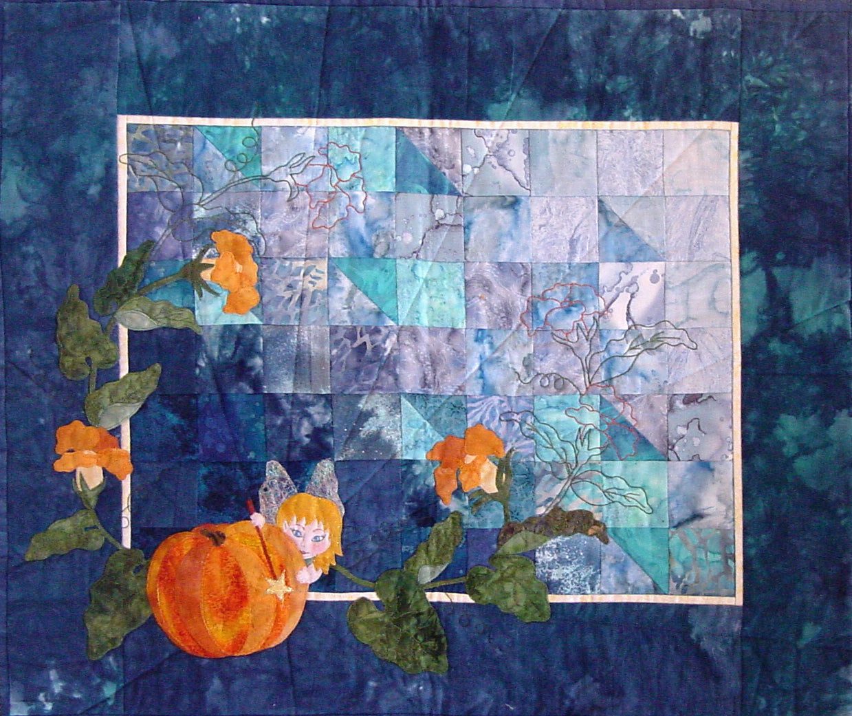 applique is used to create a pumpkin vine, pumpkin, and fairy on a color wash patchwork background of this quilt