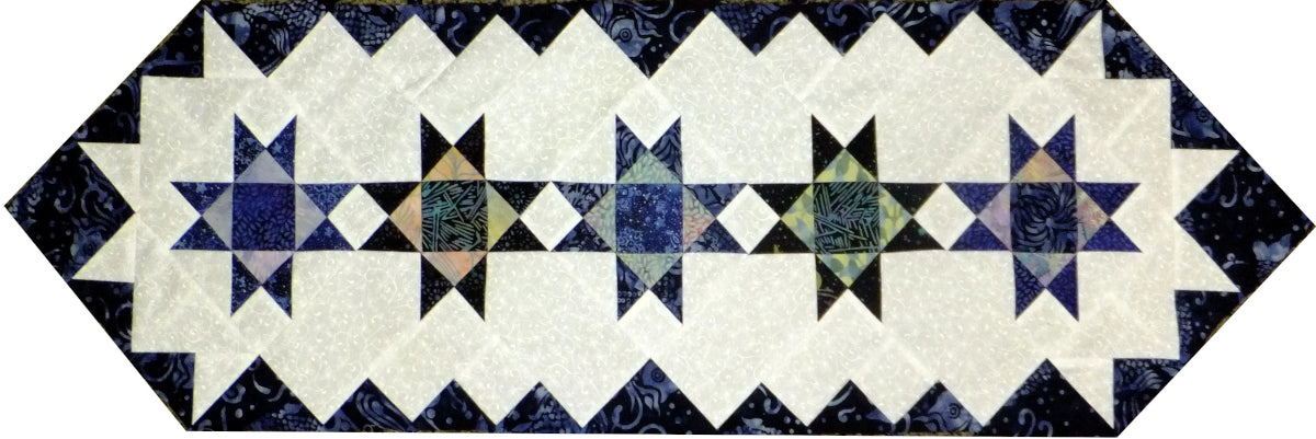 table runner quilt pattern created in batik fabrics with stars, colored border and pointed ends