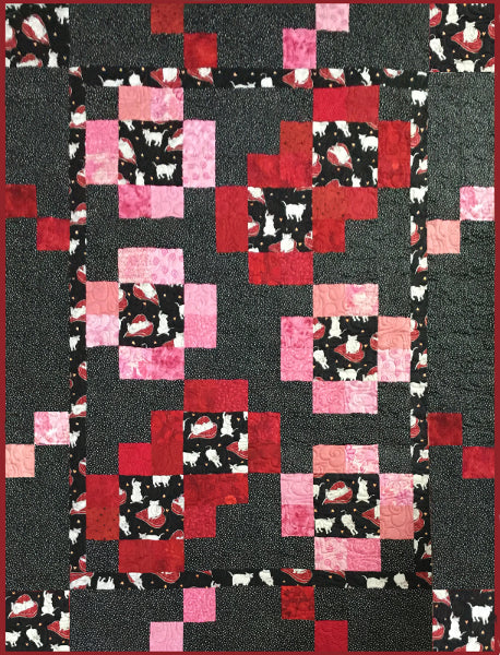 Stepping stones quilt pattern made by Sue Salinger and designed by Ruth Blanchet. It uses a theme fabric of cats which is enhanced with pink red and black