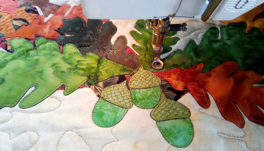 close up stitching of thanksgiving quilt with acorns and leaves