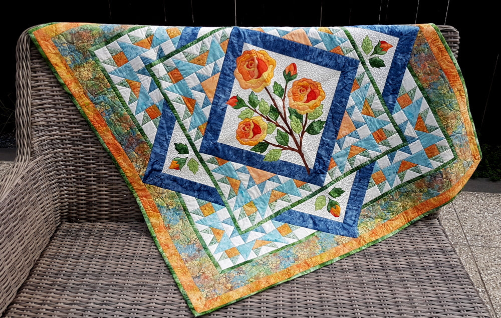 Ruth Blanchet's rose quilt displayed on outside furniture showing the centeral applique rose panel with surrounding patchwork